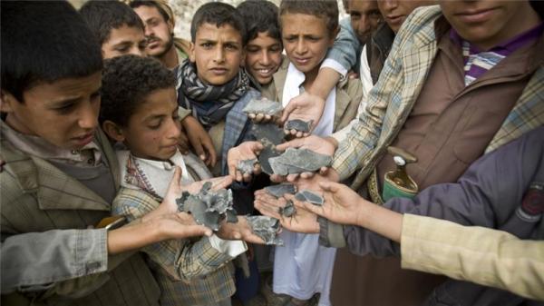 Yemeni boys display shrapnel they collected from the rubble of houses destroyed by air strikes in Yemen near Sanaa